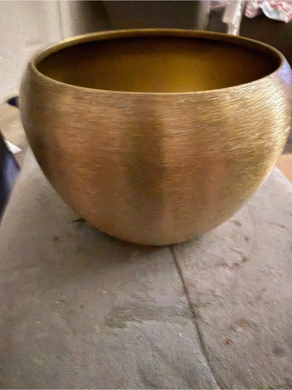 modern, round metal vase or planter with a brushed gold finish.